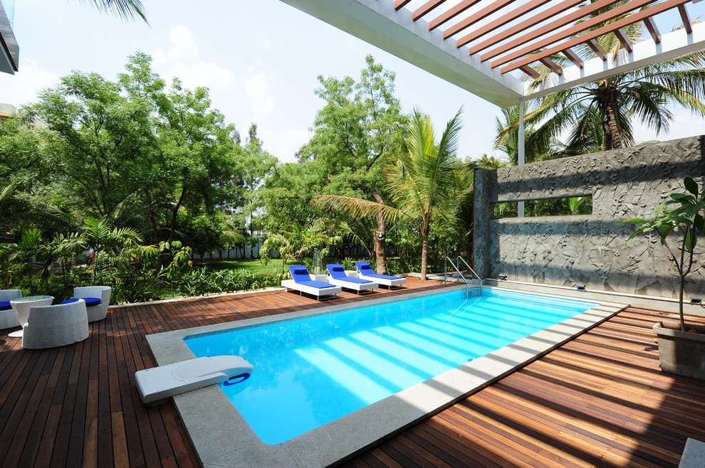 Large tropical backyard rectangular pool in Other.
