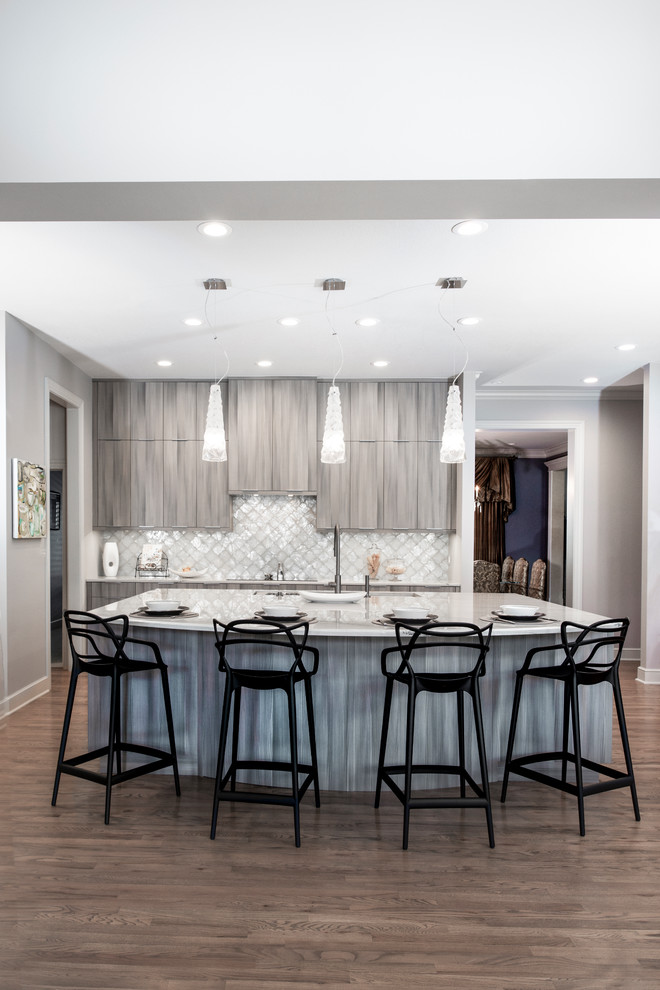 Example of a large transitional medium tone wood floor and brown floor open concept kitchen design with an undermount sink, flat-panel cabinets, brown cabinets, quartzite countertops, white backsplash, ceramic backsplash, stainless steel appliances, an island and beige countertops