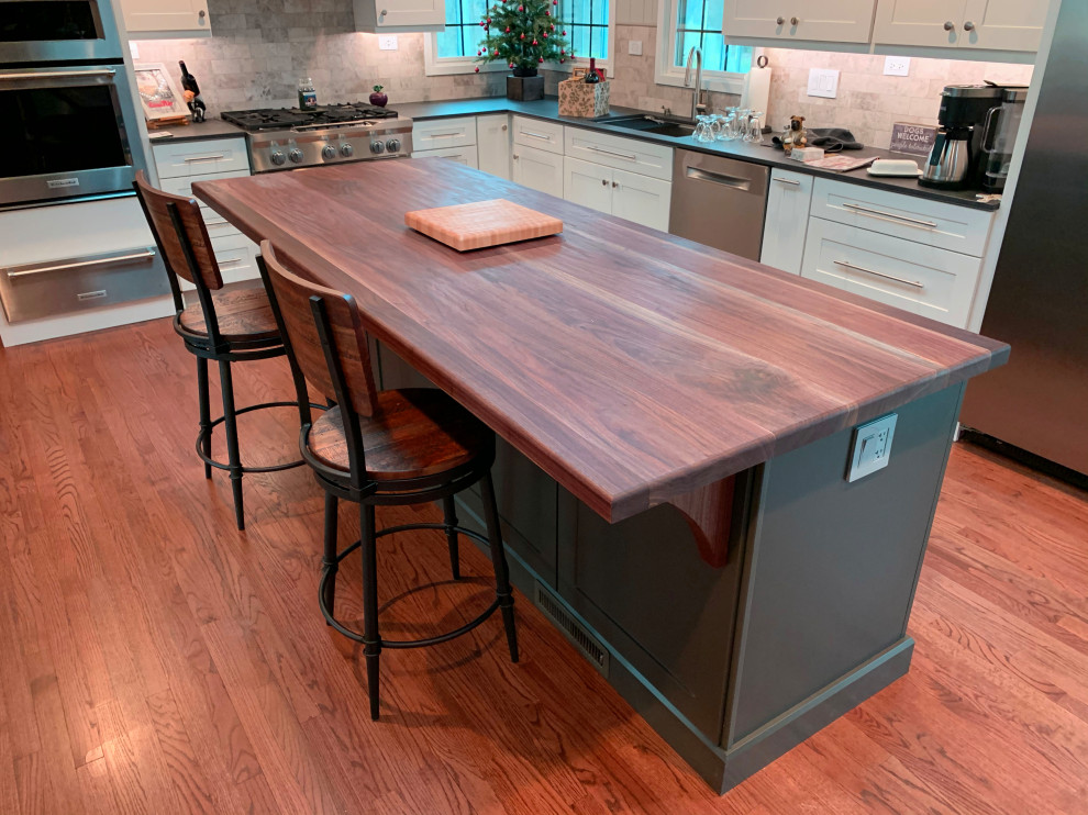 Large trendy galley medium tone wood floor eat-in kitchen photo in Chicago with an integrated sink, wood countertops, stainless steel appliances, an island and brown countertops