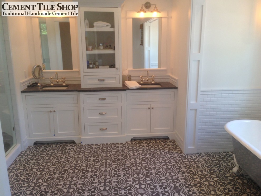 Elegant master gray tile and cement tile claw-foot bathtub photo in Phoenix with white cabinets, an undermount sink, granite countertops and white walls