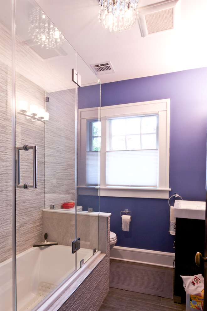 Design ideas for a mid-sized contemporary kids bathroom in New York with dark wood cabinets, a corner tub, a shower/bathtub combo, a two-piece toilet, gray tile, purple walls, porcelain floors and an integrated sink.