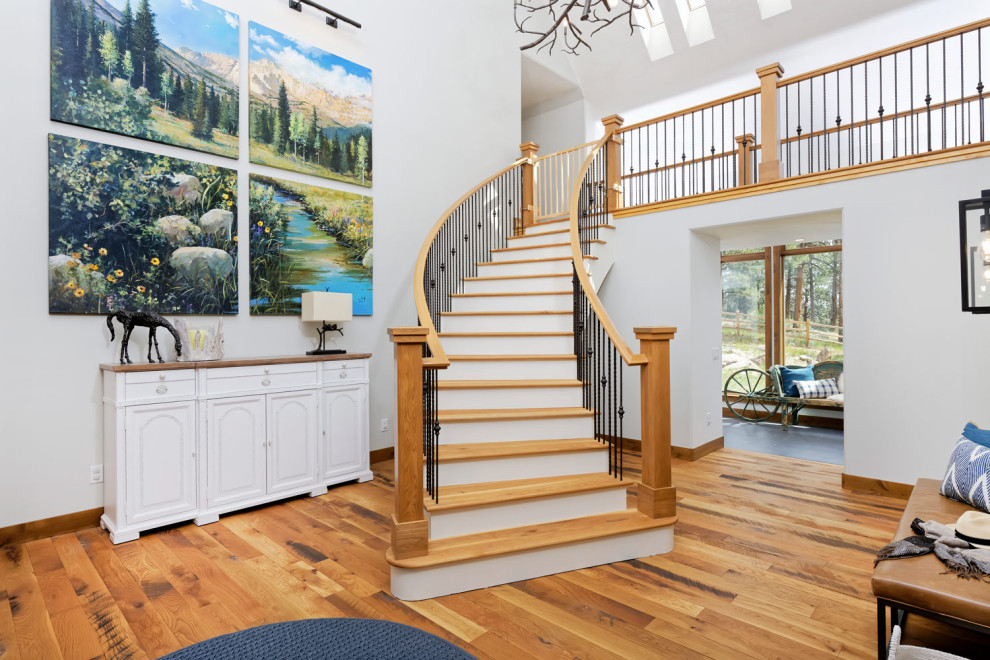 Inspiration for a mid-sized country wood curved staircase in Denver with wood risers and metal railing.