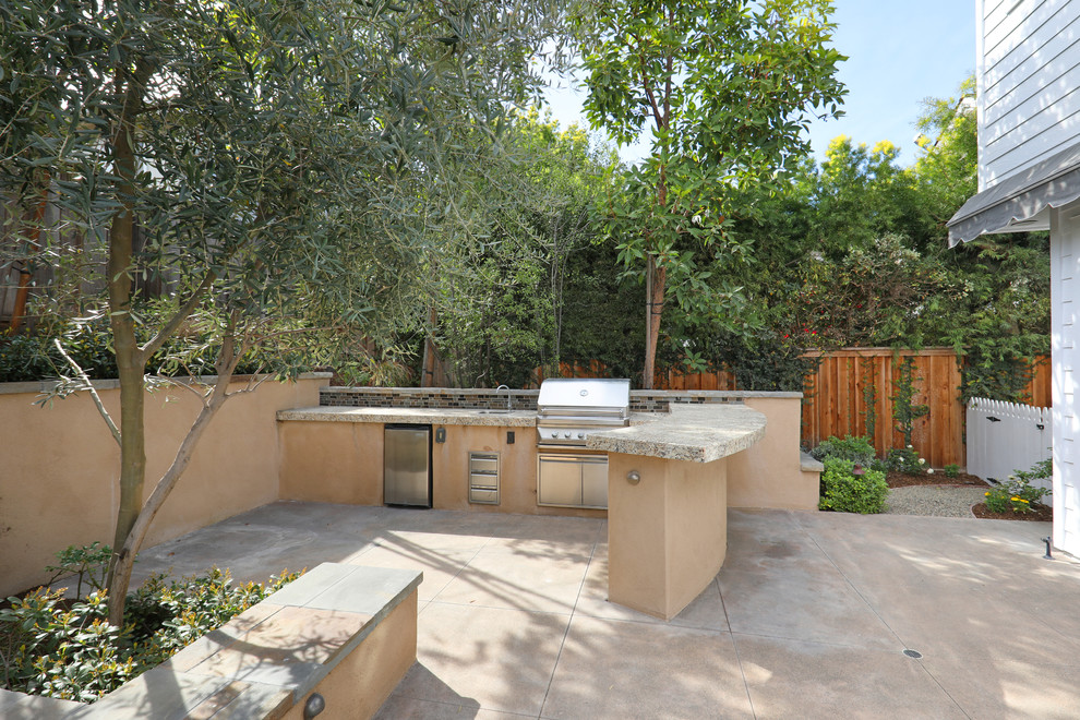 Photo of a mid-sized transitional backyard patio in Orange County with natural stone pavers, an outdoor kitchen and an awning.