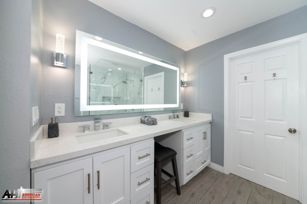 Свежая идея для дизайна: главная ванная комната среднего размера в стиле модернизм с фасадами с выступающей филенкой, белыми фасадами, угловым душем, унитазом-моноблоком, белой плиткой, мраморной плиткой, серыми стенами, полом из керамогранита, накладной раковиной, мраморной столешницей, серым полом, душем с распашными дверями, белой столешницей, сиденьем для душа, тумбой под две раковины и встроенной тумбой - отличное фото интерьера
