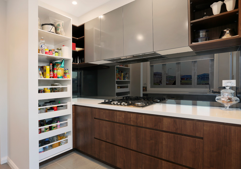 Inspiration for a large contemporary galley open plan kitchen in Sydney with an undermount sink, flat-panel cabinets, quartz benchtops, metallic splashback, mirror splashback, stainless steel appliances, porcelain floors, with island, grey floor, white benchtop and dark wood cabinets.