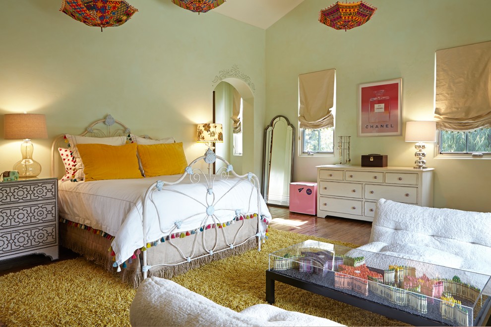 This is an example of a large transitional kids' room for girls in Los Angeles with green walls and dark hardwood floors.