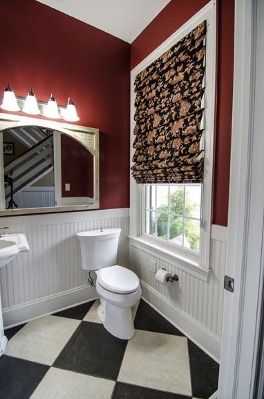 Mid-sized traditional powder room in Philadelphia with a pedestal sink, a one-piece toilet, red walls and black and white tile.
