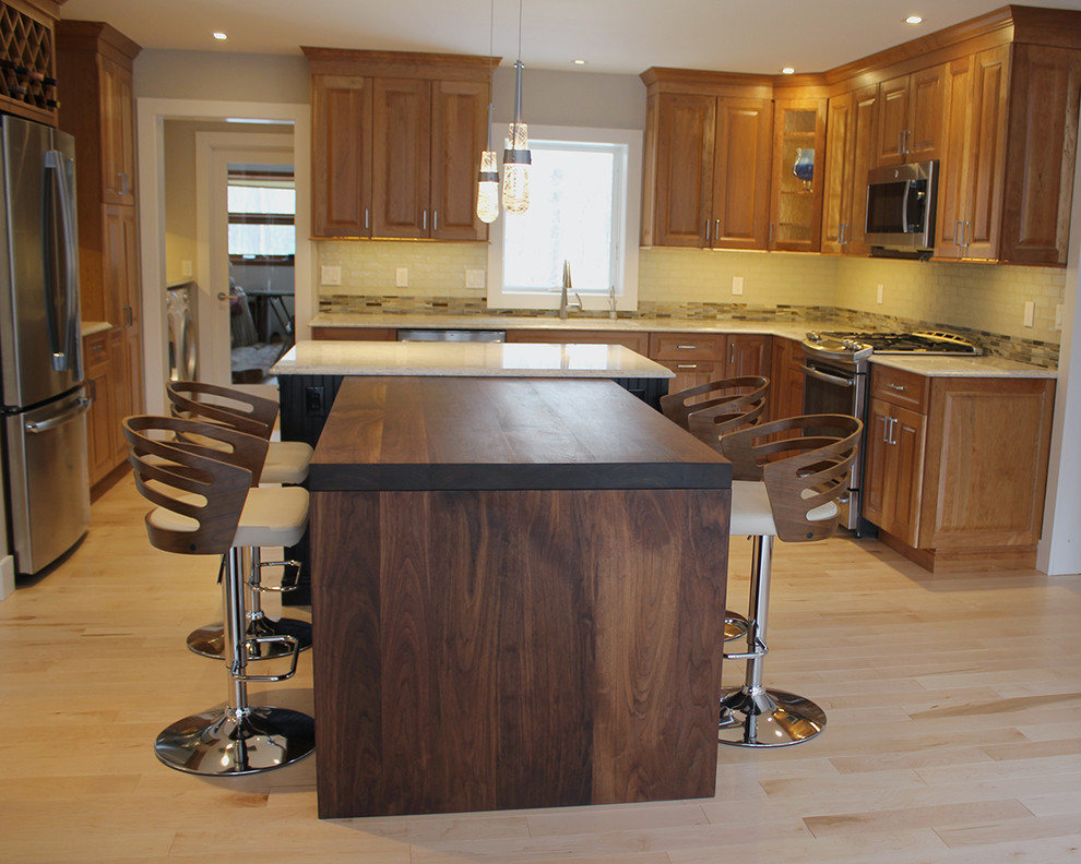 Inspiration for a large transitional u-shaped light wood floor and beige floor open concept kitchen remodel in Boston with an undermount sink, raised-panel cabinets, medium tone wood cabinets, quartz countertops, multicolored backsplash, glass tile backsplash, stainless steel appliances, an island and beige countertops