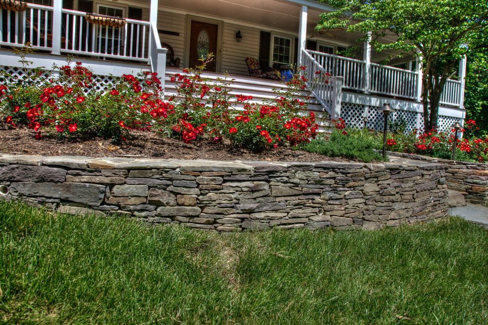 Photo of a mid-sized partial sun front yard mulch retaining wall landscape in DC Metro.