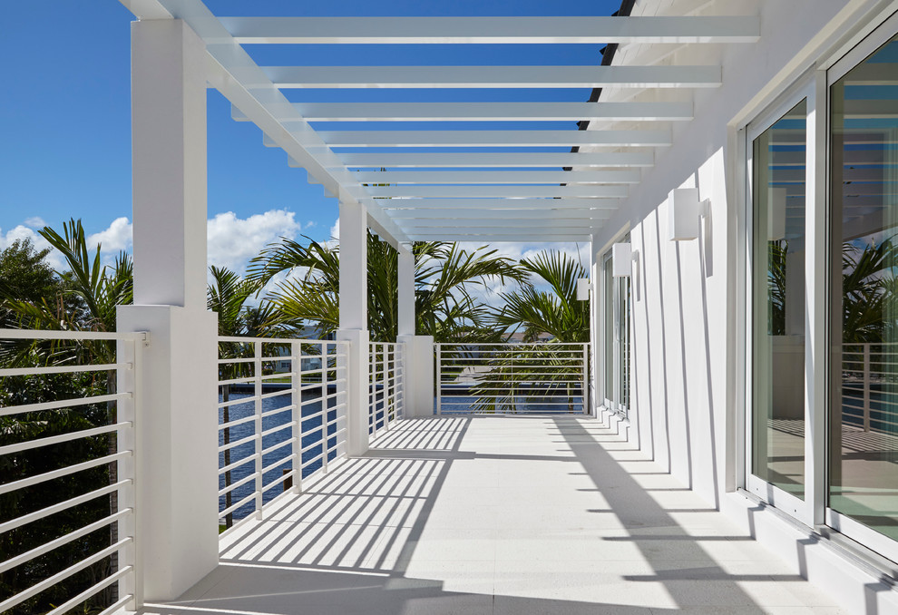 Large contemporary balcony in Miami with a pergola.