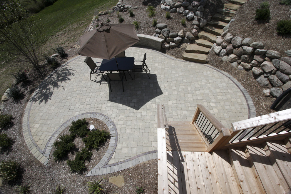 Design ideas for a large traditional backyard patio in Detroit with concrete pavers and no cover.