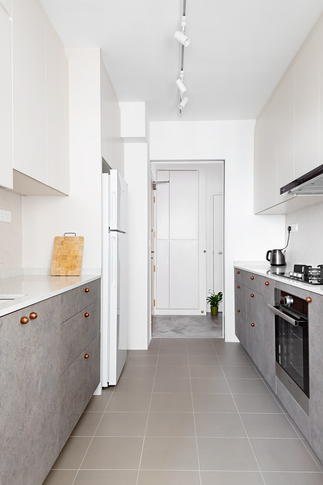 This is an example of a scandinavian galley separate kitchen in Singapore with an undermount sink, flat-panel cabinets, grey cabinets, stainless steel appliances, no island, grey floor and white benchtop.