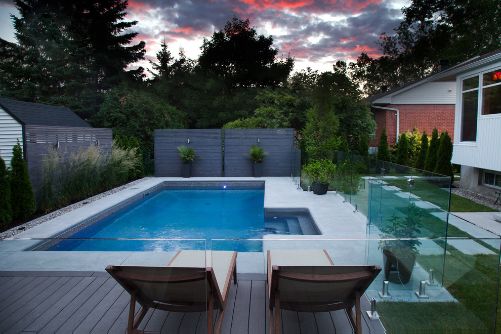 Contemporary backyard rectangular pool in Montreal with concrete slab.