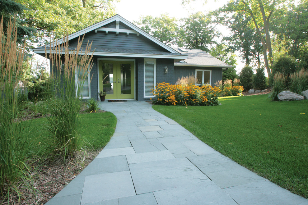 Photo of a small beach style front yard driveway in Minneapolis with natural stone pavers.