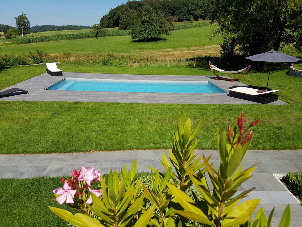 Großer, Gefliester Mediterraner Pool neben dem Haus in rechteckiger Form in Frankfurt am Main