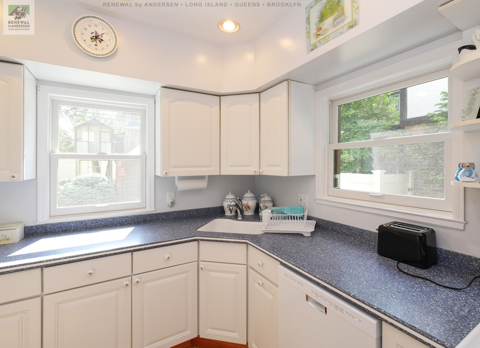 Foto di una piccola cucina a L chiusa con lavello sottopiano, ante bianche, top in granito, elettrodomestici bianchi, pavimento in legno massello medio e top blu
