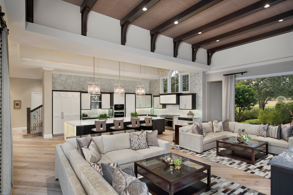Large transitional open concept living room in Miami with beige walls and light hardwood floors.