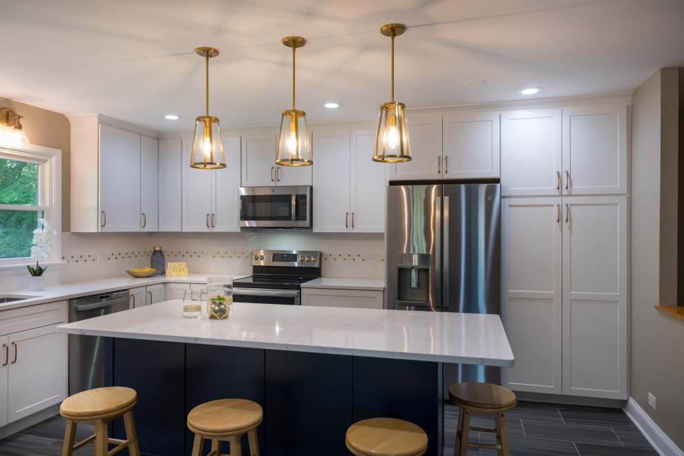 Large transitional u-shaped porcelain tile and gray floor open concept kitchen photo in Chicago with an undermount sink, shaker cabinets, white cabinets, quartz countertops, white backsplash, ceramic backsplash, stainless steel appliances, an island and white countertops