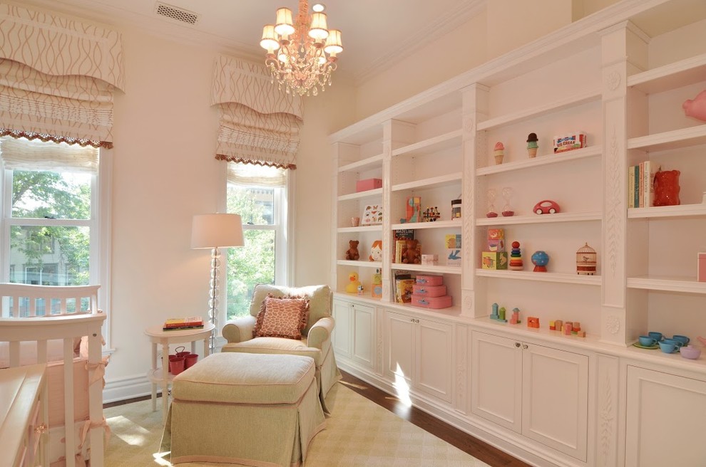 Inspiration for a mid-sized traditional nursery for girls in Chicago with beige walls and medium hardwood floors.