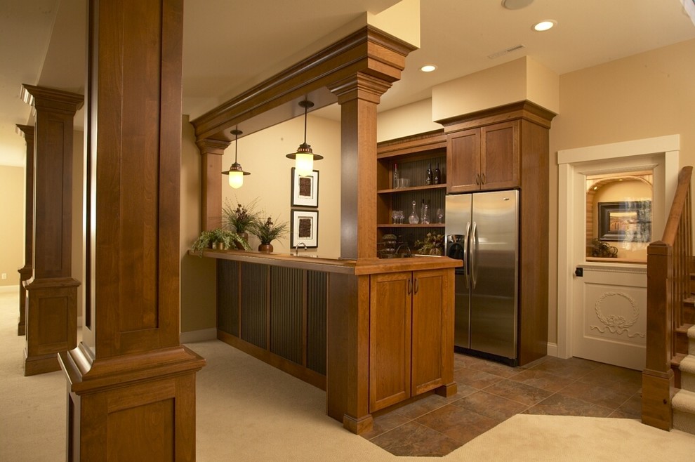 Design ideas for a mid-sized arts and crafts galley seated home bar in Cedar Rapids with shaker cabinets, dark wood cabinets, wood benchtops, ceramic floors and beige floor.