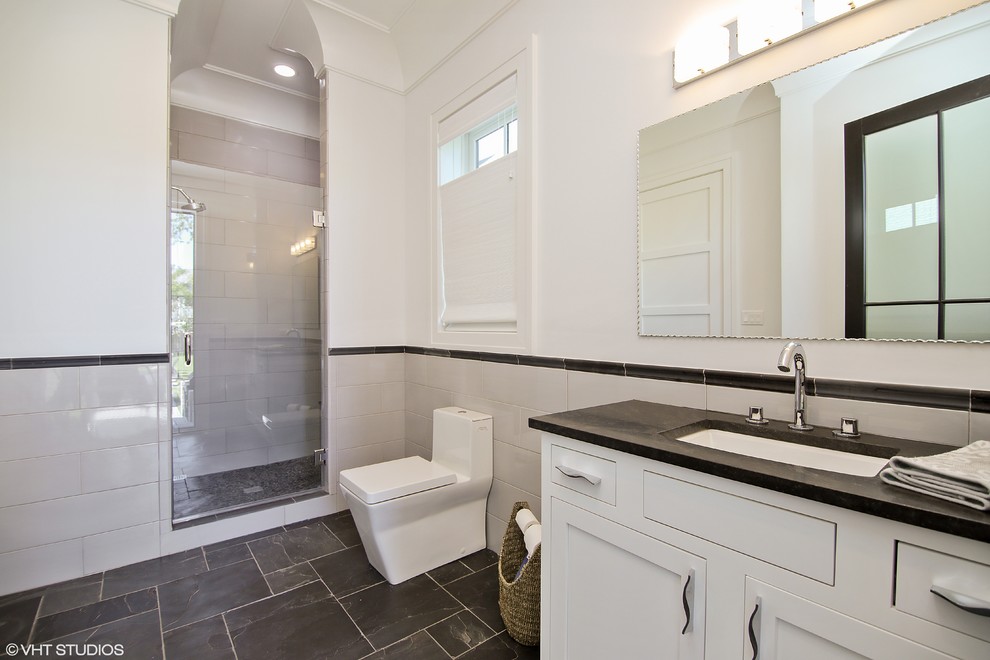 Photo of a modern kids bathroom in Chicago with shaker cabinets, yellow cabinets, an alcove shower, a one-piece toilet, gray tile, white walls, slate floors and soapstone benchtops.