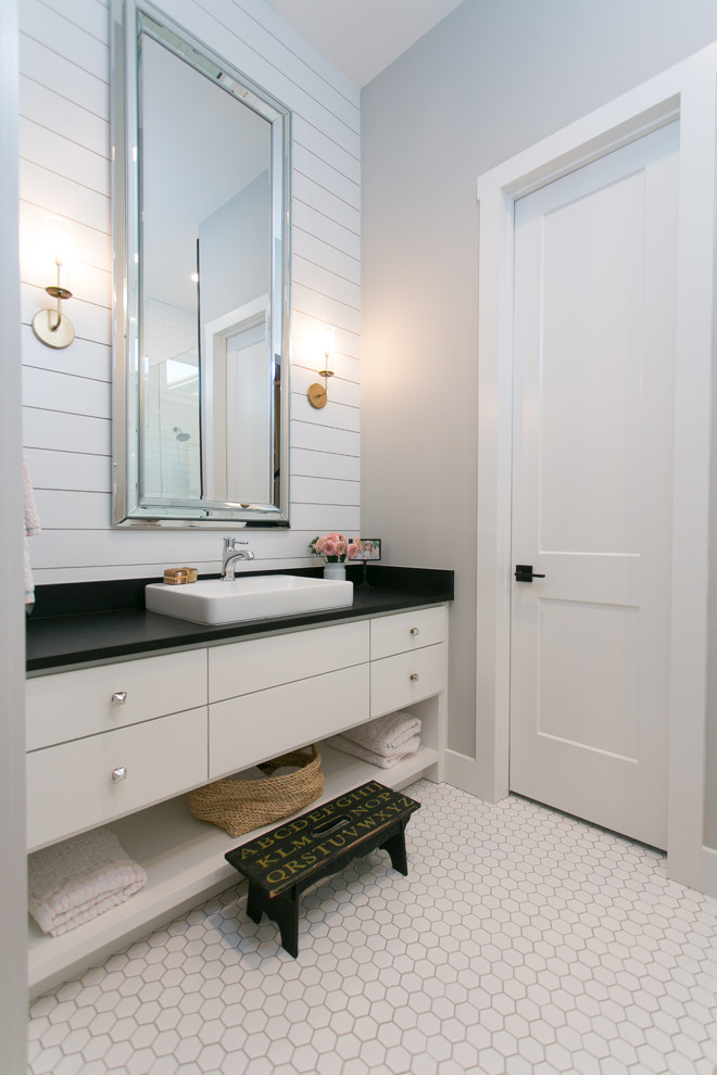 Inspiration for a mid-sized country kids bathroom in Austin with flat-panel cabinets, white cabinets, a freestanding tub, an alcove shower, a one-piece toilet, gray tile, grey walls, ceramic floors, a vessel sink, granite benchtops, white floor and a hinged shower door.