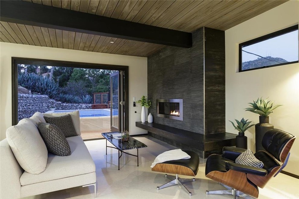 Photo of a mid-sized modern enclosed family room in Los Angeles with white walls, linoleum floors, a ribbon fireplace, a metal fireplace surround and no tv.