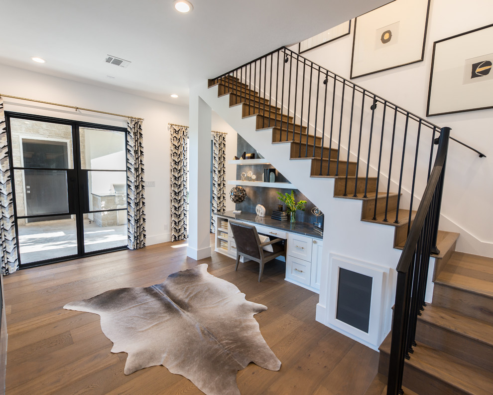 This is an example of a wood u-shaped staircase in Austin with wood risers and metal railing.