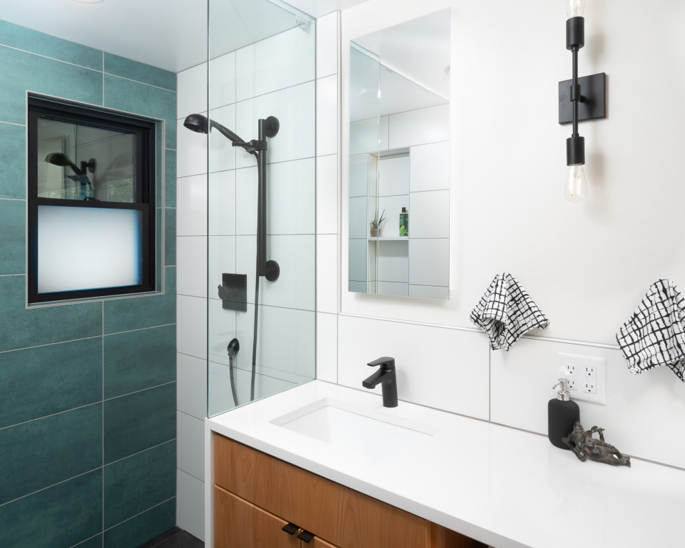 Small modern ensuite bathroom in Other with shaker cabinets, light wood cabinets, a built-in shower, a one-piece toilet, green tiles, ceramic tiles, white walls, ceramic flooring, a submerged sink, quartz worktops, grey floors, an open shower, white worktops, a wall niche, double sinks and a built in vanity unit.