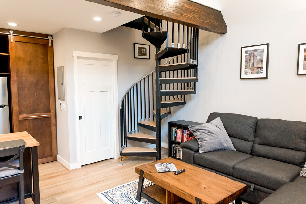 This is an example of a small traditional wood spiral staircase in Portland with metal risers and metal railing.