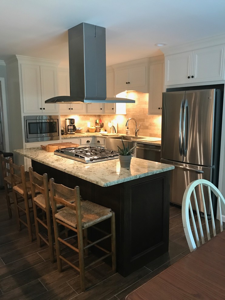 Inspiration for a large transitional l-shaped brown floor eat-in kitchen remodel in Birmingham with a farmhouse sink, recessed-panel cabinets, white cabinets, beige backsplash, stainless steel appliances and an island