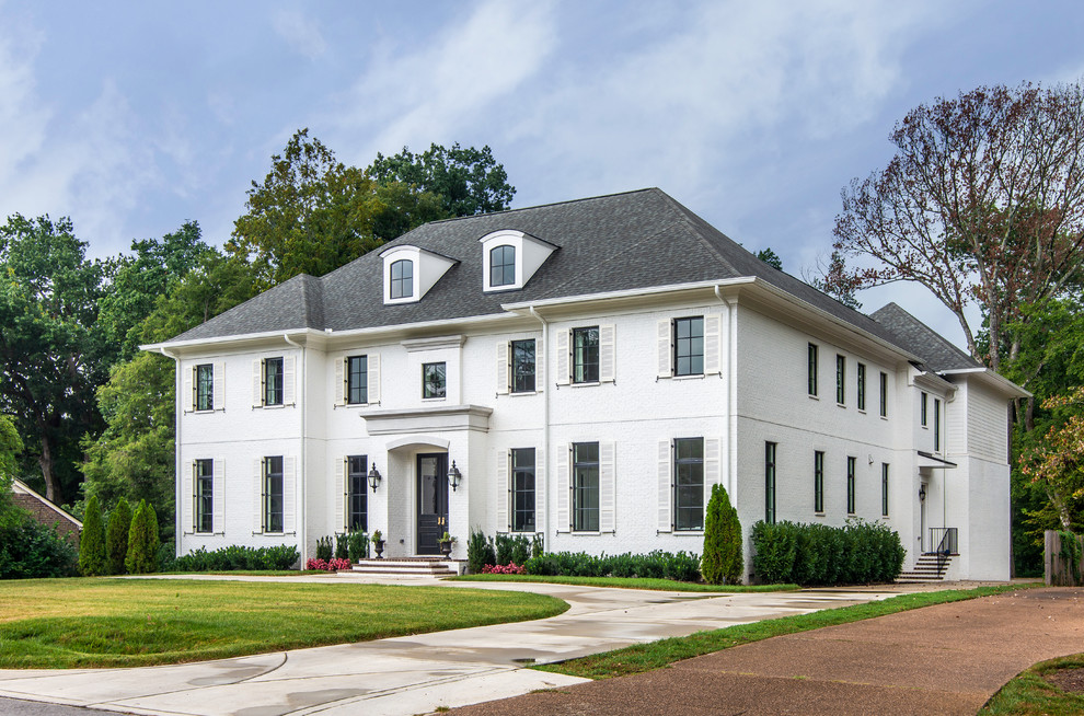 Photo of a large traditional two-storey white house exterior in Nashville with a hip roof and a shingle roof.