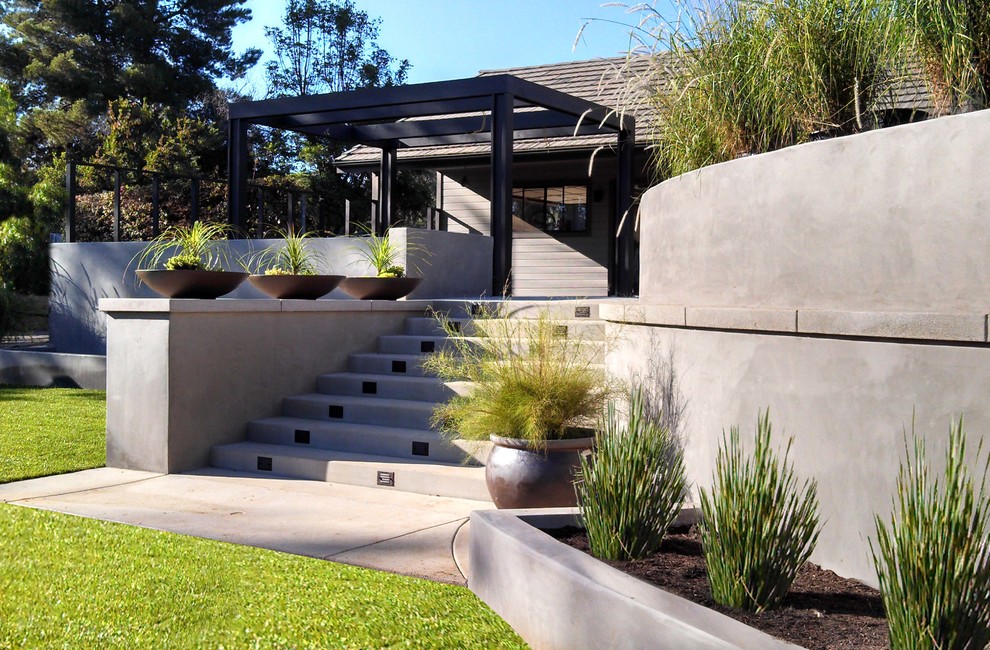 Photo of a large contemporary backyard full sun garden for spring in San Diego with a fire feature and concrete pavers.