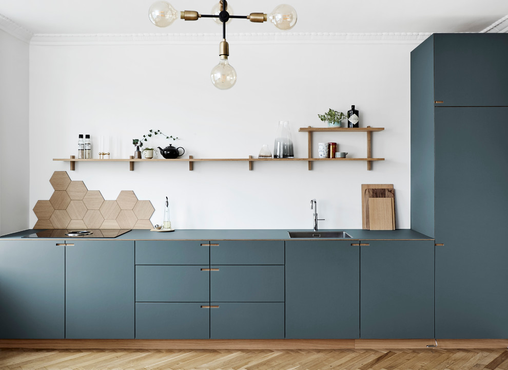 Inspiration for a large scandinavian l-shaped eat-in kitchen in Copenhagen with a single-bowl sink, flat-panel cabinets, blue cabinets, brown splashback, timber splashback, coloured appliances, medium hardwood floors, with island and brown floor.