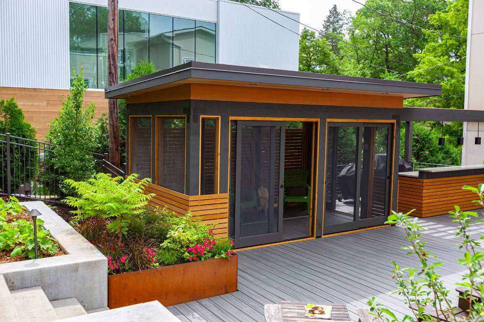 Photo of a large modern backyard screened-in verandah in Minneapolis with decking and a pergola.