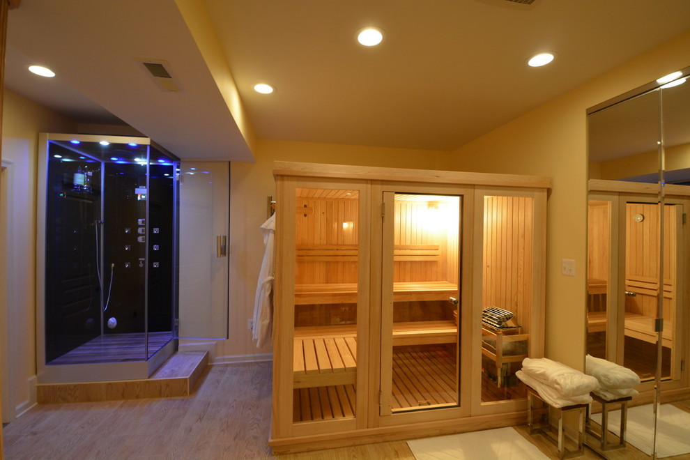Photo of a large modern bathroom in Baltimore with glass-front cabinets, a corner shower, black tile, yellow walls, light hardwood floors and with a sauna.