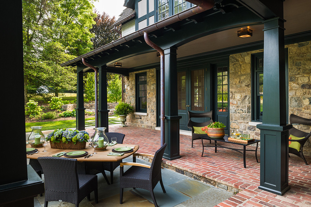 Inspiration for a large traditional backyard verandah in Philadelphia with brick pavers and a roof extension.