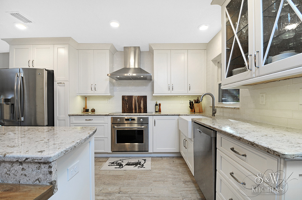 Mid-sized transitional galley porcelain tile and gray floor eat-in kitchen photo in Tampa with a farmhouse sink, flat-panel cabinets, white cabinets, quartz countertops, white backsplash, subway tile backsplash, stainless steel appliances, a peninsula and gray countertops