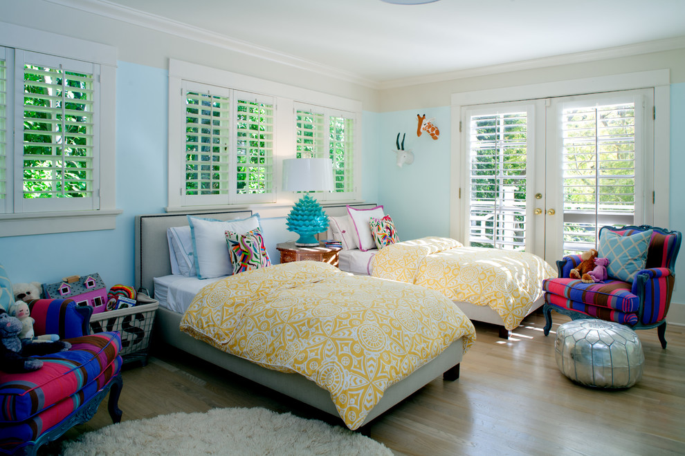 Traditional gender-neutral kids' bedroom in Los Angeles with blue walls and light hardwood floors for kids 4-10 years old.