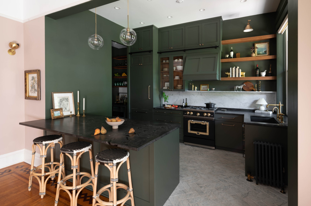 Источник вдохновения для домашнего уюта: угловая кухня с врезной мойкой, фасадами в стиле шейкер, зелеными фасадами, белым фартуком, черной техникой, полуостровом, серым полом и черной столешницей