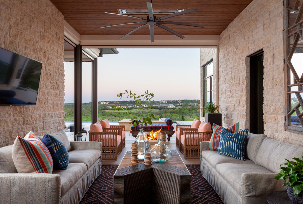 Example of a mid-sized transitional backyard patio design in Austin with a fire pit and a roof extension