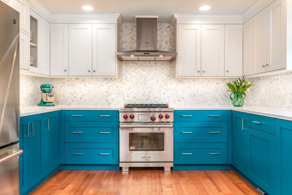 Small transitional u-shaped light wood floor kitchen pantry photo in Seattle with an undermount sink, shaker cabinets, blue cabinets, quartz countertops, white backsplash, marble backsplash, stainless steel appliances and white countertops