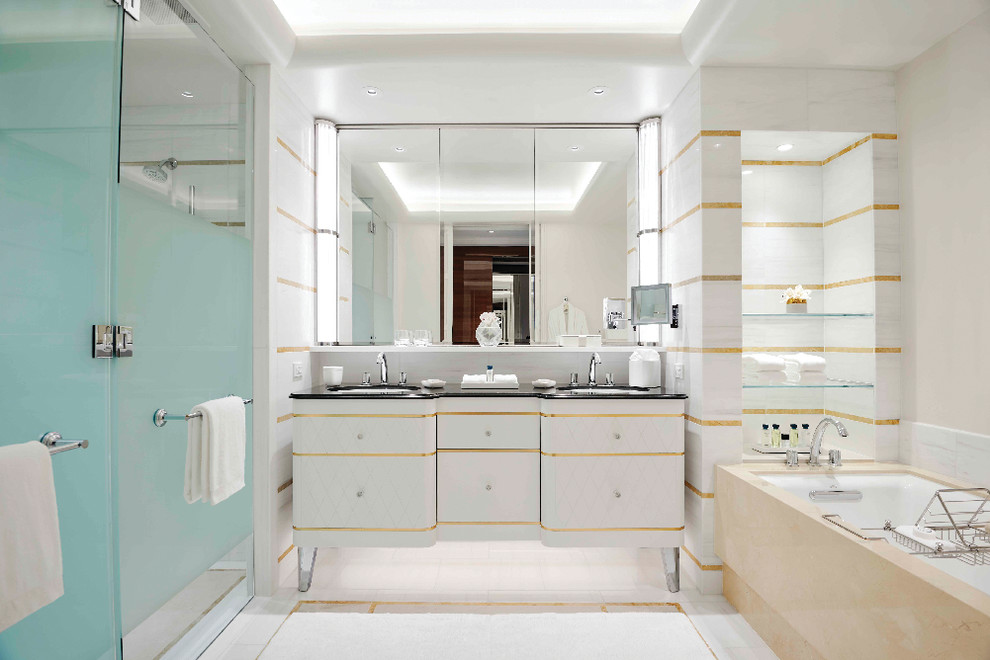 This is an example of a large modern master bathroom in Los Angeles with white cabinets, an alcove tub, multi-coloured tile, marble, multi-coloured walls, marble floors, an undermount sink, multi-coloured floor, a hinged shower door, black benchtops, beaded inset cabinets, an alcove shower and marble benchtops.