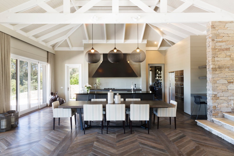 This is an example of a large country open plan dining in Melbourne with medium hardwood floors, brown floor and vaulted.