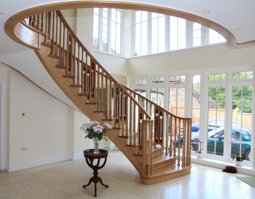 Photo of a large traditional wood curved staircase in Other with wood risers.