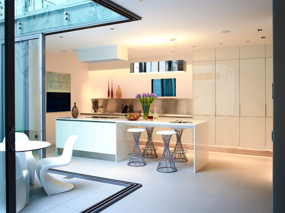 Photo of a mid-sized contemporary galley kitchen in Other with flat-panel cabinets, white cabinets, metallic splashback, panelled appliances and with island.