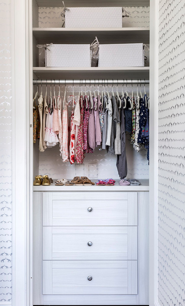 This is an example of a transitional storage and wardrobe in New York with open cabinets and white cabinets.
