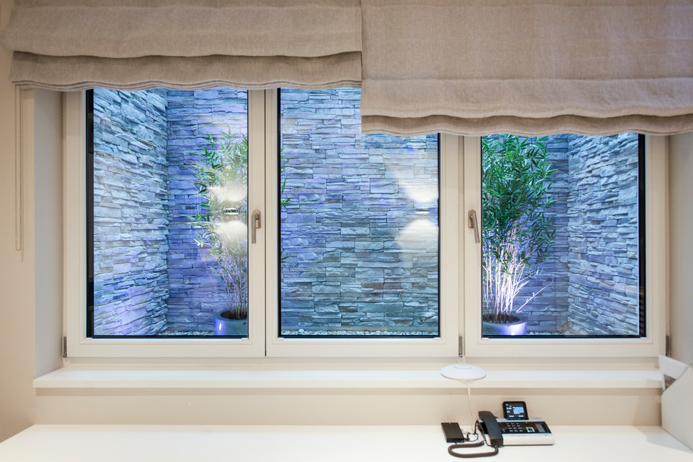 Mittelgroßes Modernes Untergeschoss mit weißer Wandfarbe, Keramikboden und grauem Boden in München