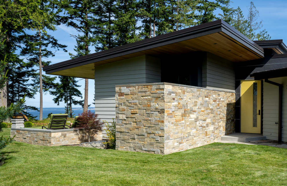 Esempio della facciata di una casa multicolore moderna a un piano di medie dimensioni con rivestimenti misti, copertura in metallo o lamiera, tetto nero, pannelli sovrapposti e abbinamento di colori