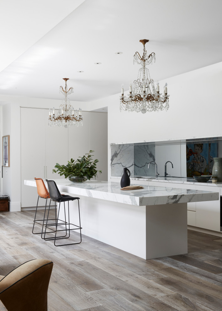 This is an example of a large contemporary kitchen pantry in Melbourne with flat-panel cabinets, marble benchtops, medium hardwood floors and with island.